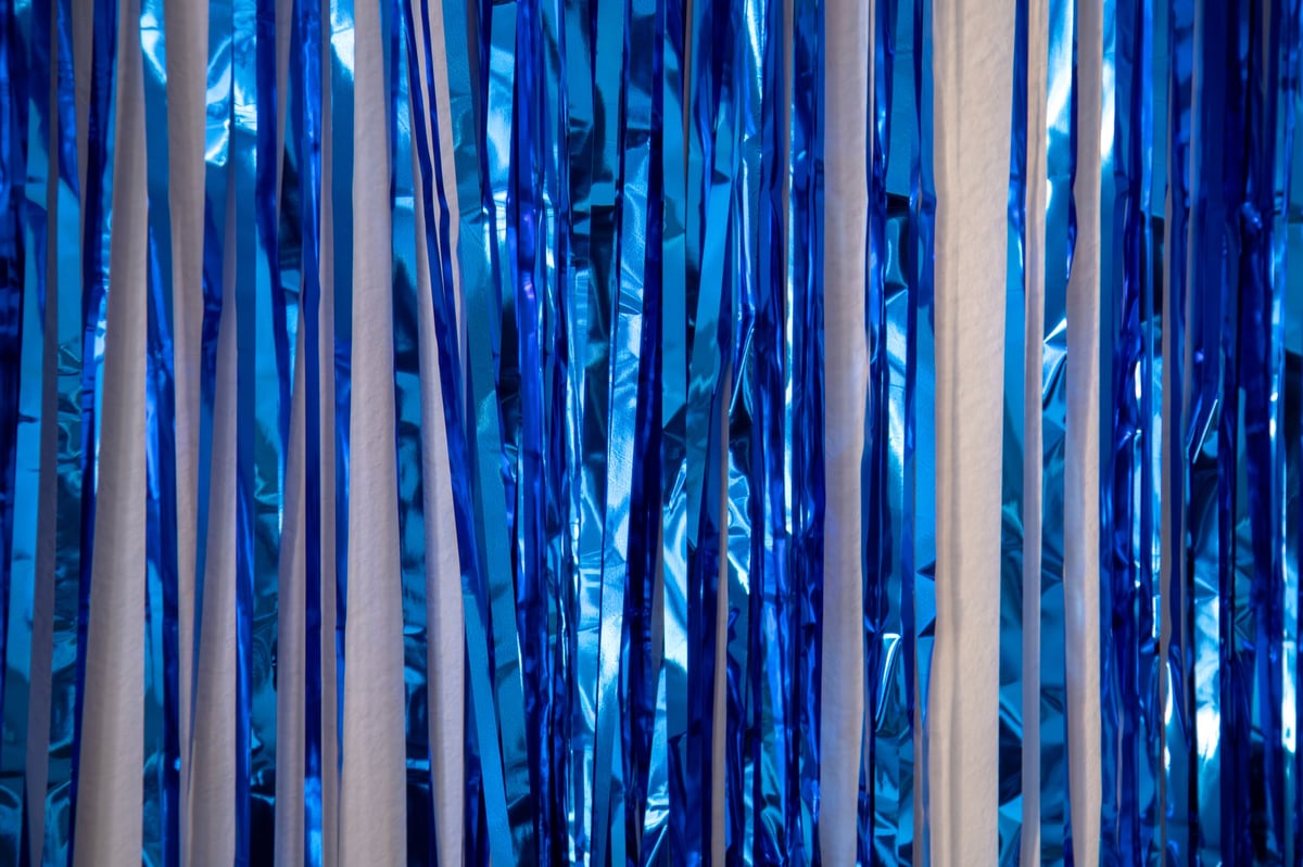 Vibrant blue and white photo booth backdrop with streamers
