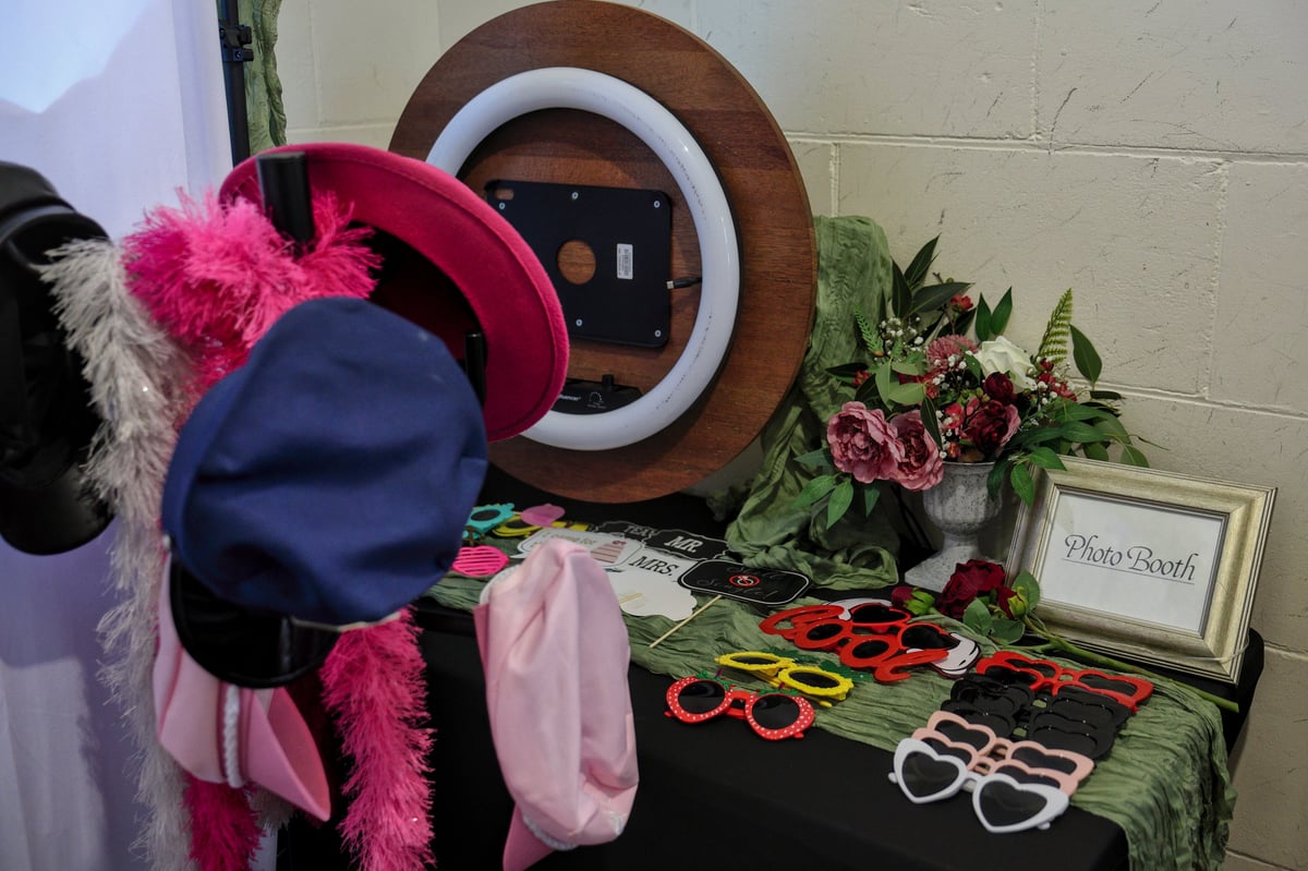 Photo booth prop table with gold-framed sign and party accessories